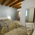 Tenuta Cavalieri in Leverano bedroom with double bed, wood-beamed ceiling and air conditioning