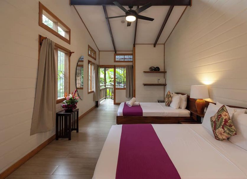 Pachira Lodge, Tortuguero: bright guest room with two beds, ceiling fan, and view to greenery
