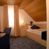 Garni-Hotel Adler in Ostfildern guest room with desk, chair, bed, and sloped wood ceiling