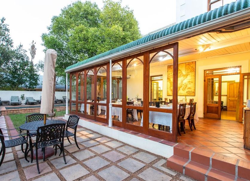 Evergreen Manor and Spa, Stellenbosch: glass-enclosed patio dining area with outdoor seating and garden view