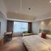 Wanhao International Hotel Benxi guest room with king bed, desk, sofa, and large window