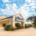 Baymont by Wyndham Topeka exterior with covered entrance and landscaped drive under a blue sky