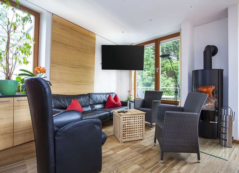 Gästehaus Otto Huber Hotel Garni lounge in Oberammergau with sofa, fireplace, and large windows