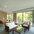 Atami Club Geihinkan suite with sofa seating and floor-to-ceiling windows overlooking greenery in Atami