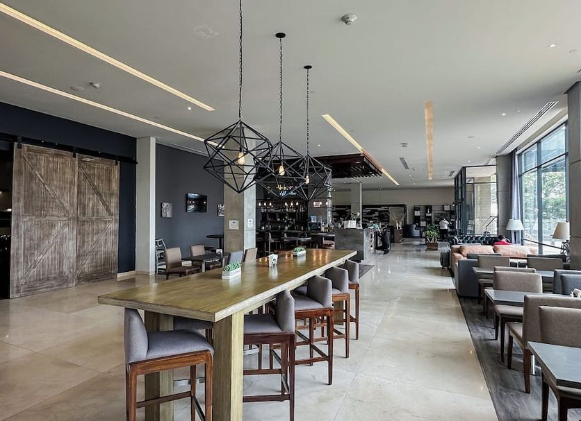 Hampton Inn by Hilton Celaya lobby lounge with long communal table, bar seating and large windows