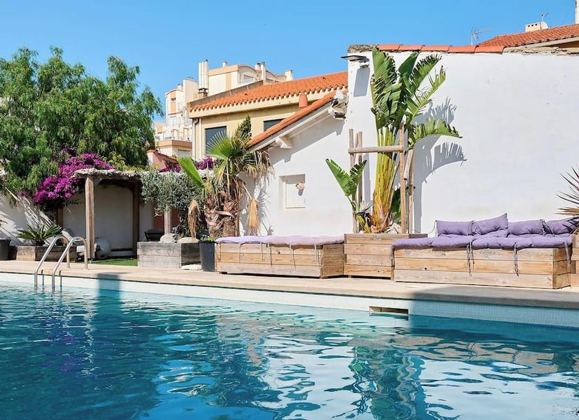 Hôtel Les Sables - Urban Style poolside terrace with lounge seating and palm plants in Canet-en-Roussillon