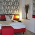 Cityhotel Ahlen Garni in Ahlen: double bed with red headboard and patterned wallpaper in guest room