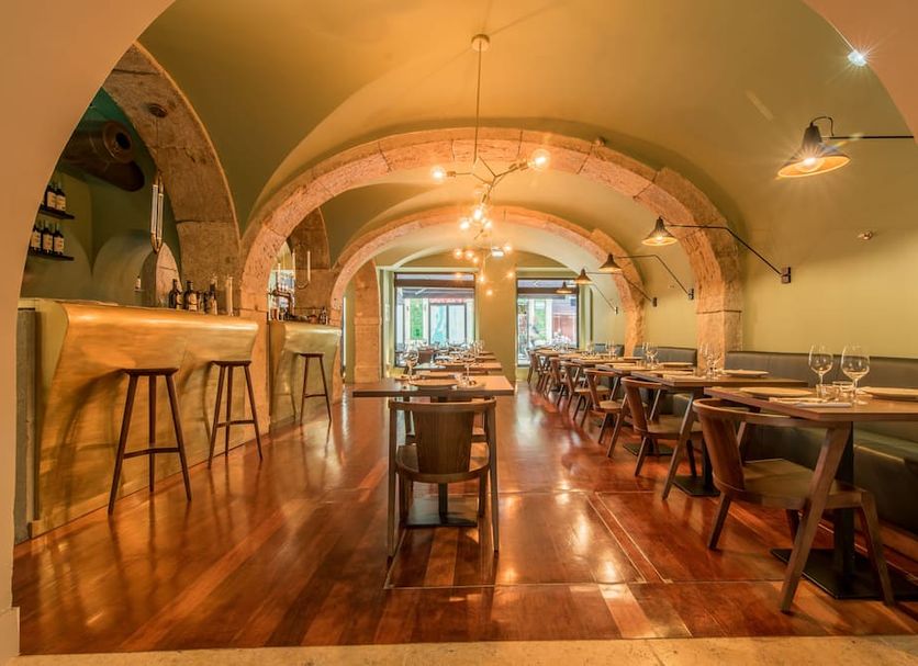 Hotel Da Baixa Lisbon dining room with arched ceilings, wooden floors and long tables