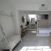 Radio Tulum guest room with bed alcove, swing chair, and rustic table in Tulum