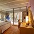 La Freixera in Solsona guest room with stone walls, bed, desk and sliding glass doors to a patio