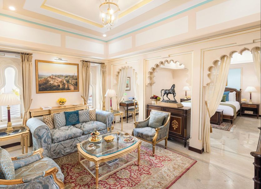Elegant suite at Taj Fateh Prakash Palace Udaipur with ornate seating, chandelier, and bedroom views