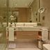 Onyx Rotana Manama bathroom with glass shower, double vanity, and illuminated mirror