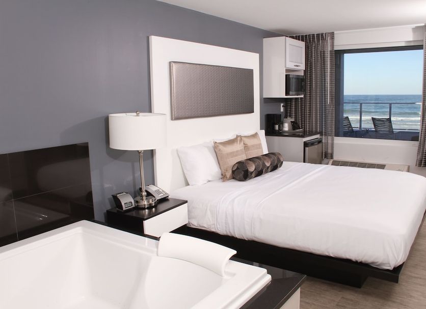 Lotus Boutique Inn & Suites room with ocean-view balcony, king bed, and soaking tub in Ormond Beach