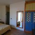 Resort Itaca - Nausicaa room in Rossano with bed, mirror, and blue wardrobe