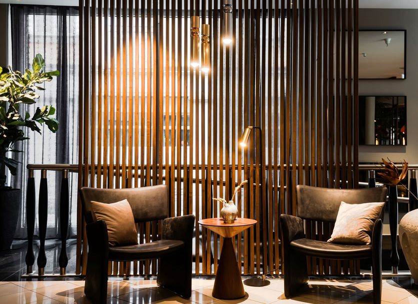 Elite Hotel Esplanade in Malmö lounge with two armchairs, side table and warm wood slat partition