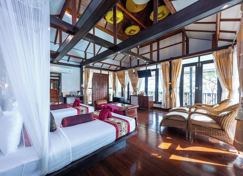 Phi Phi Natural Resort in Ko Phi Phi guest room with canopy bed, wood floors and balcony seating