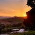 Sunset over Tuscan hills with pool umbrellas at Fonteverde Lifestyle & Thermal Retreat, San Casciano Dei Bagni