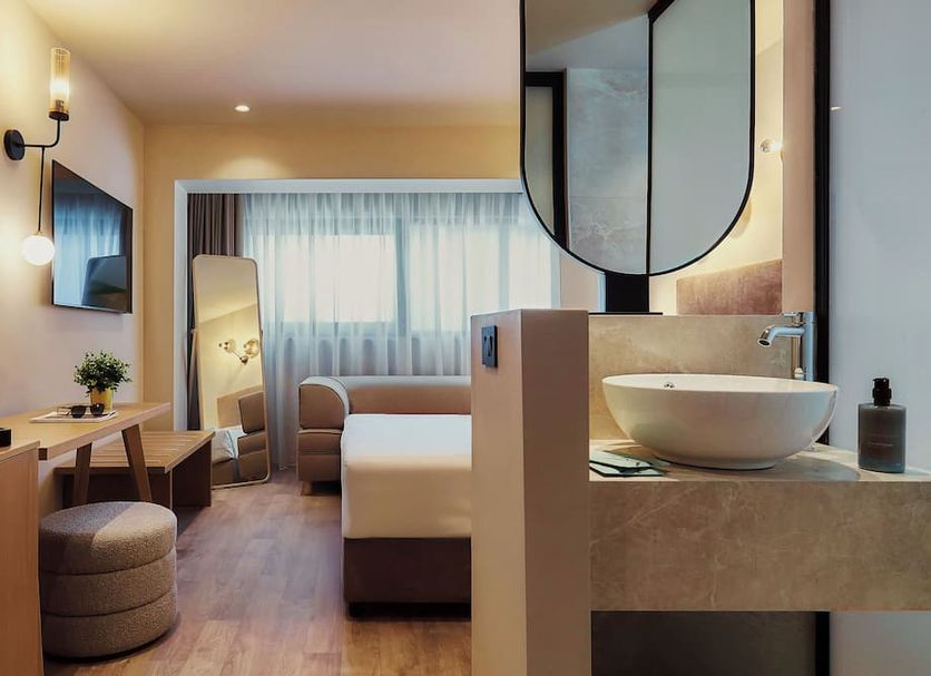 Venus Melena in Hersonissos guest room with vanity sink, bed, desk and bright window view