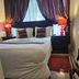 The Royal Princess Garden - Randburg guest room with bed, red lamps, and heavy drapes