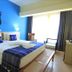 Hotel Santa Maria Praia guest room with double bed, blue accent wall, and balcony seating