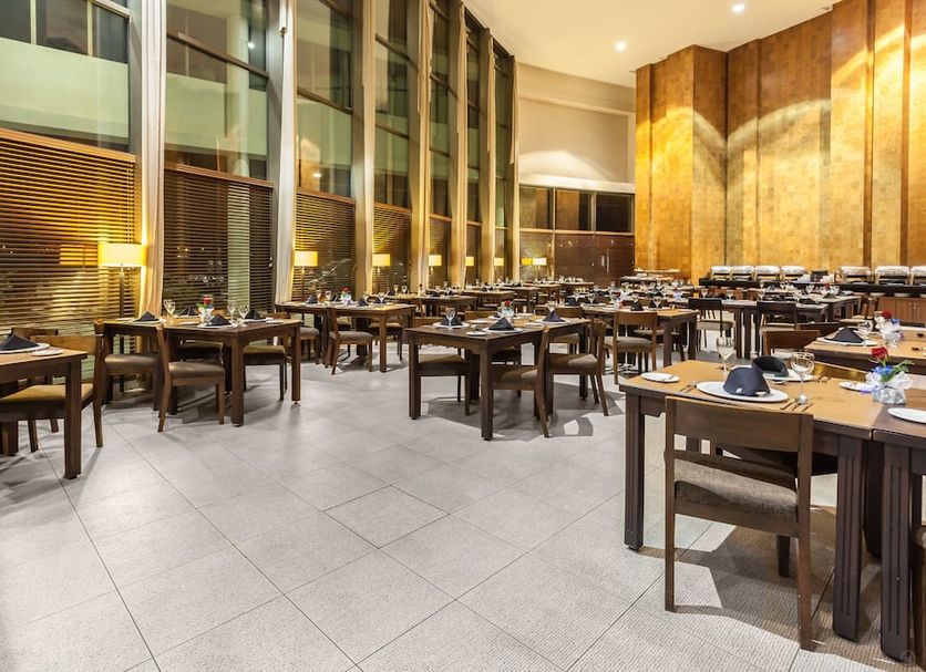 Sonesta Hotel Osorno restaurant dining area in Osorno with set tables and tall windows