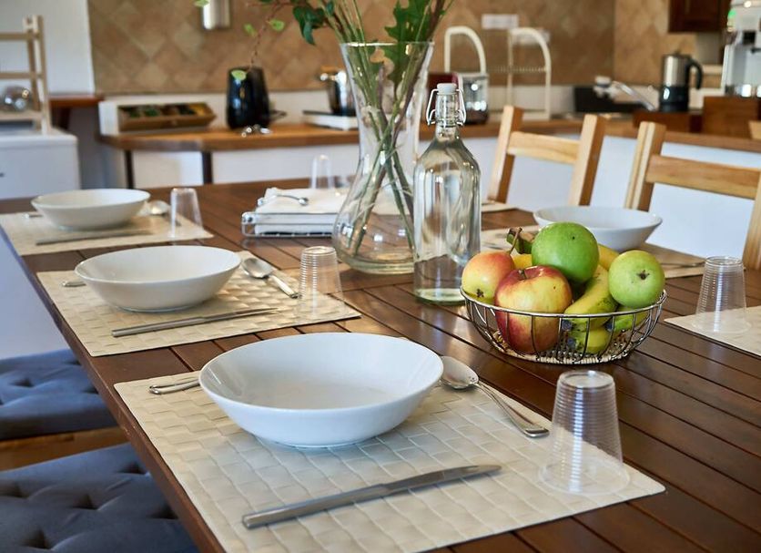 B&B La Suite, Milazzo: dining table set with bowls, glassware and a fruit basket in a breakfast room