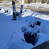 Landhotel Ewerts in Nuerburg: snow-covered terrace with potted plants beside a river
