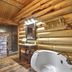 Hibernation Station in West Yellowstone features a rustic log bathroom with jetted tub and stone shower