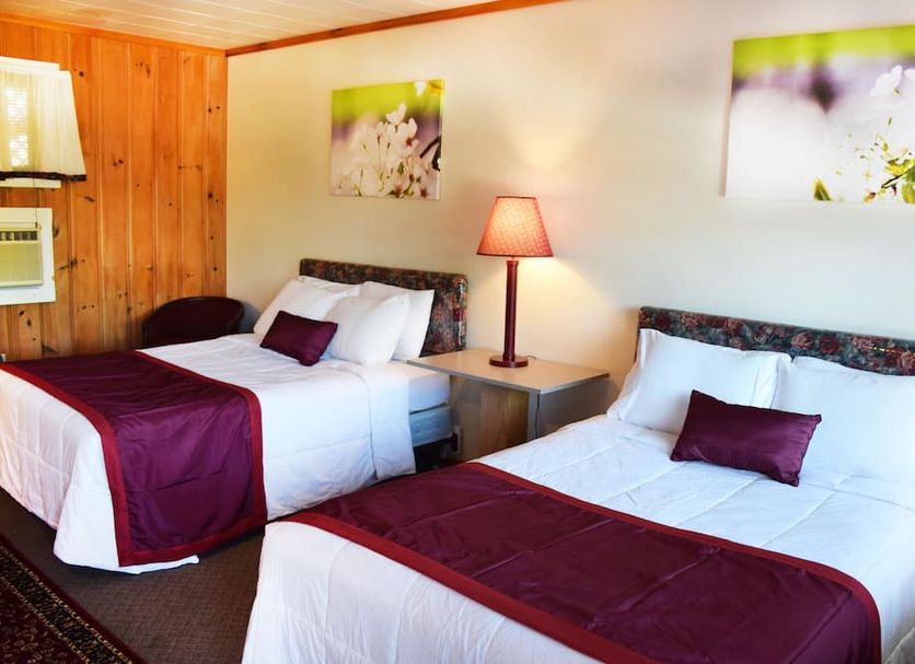 Inn on The Hill in Lake George guest room with two beds, burgundy accents, and wood-paneled wall