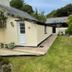 Frogwell in Dartmouth with a cream cottage-style exterior, patio walkway, and lawn seating area.