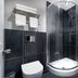 Qudos Salisbury bathroom with curved glass shower, toilet, sink vanity and towel rack