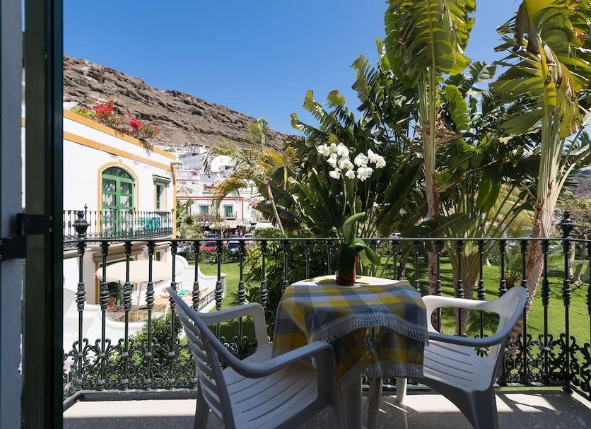 La Venecia de Canarias Puerto de Mogan terrace with table, chairs, potted flowers and mountain view in Mogán