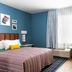 Uptown Suites Extended Stay Denver Co - Centennial room with bed, desk, seating area and large window