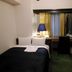 Shinjuku Hotel Parkinn guest room in Tokyo with bed, desk, chair and window curtains