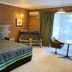 Kingswood Motel in Tocumwal guest room with king bed, chairs, table and large window with curtains.