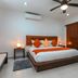 Casa Ticul Hotel By Bfh in Playa del Carmen: bedroom with king bed, orange accents, and ceiling fan