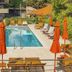 Hotel Aquarius Dubrovnik in Dubrovnik: outdoor pool with orange umbrellas and lounge chairs