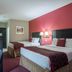 Ramada by Wyndham 100 Mile House guest room with two beds and red accent wall