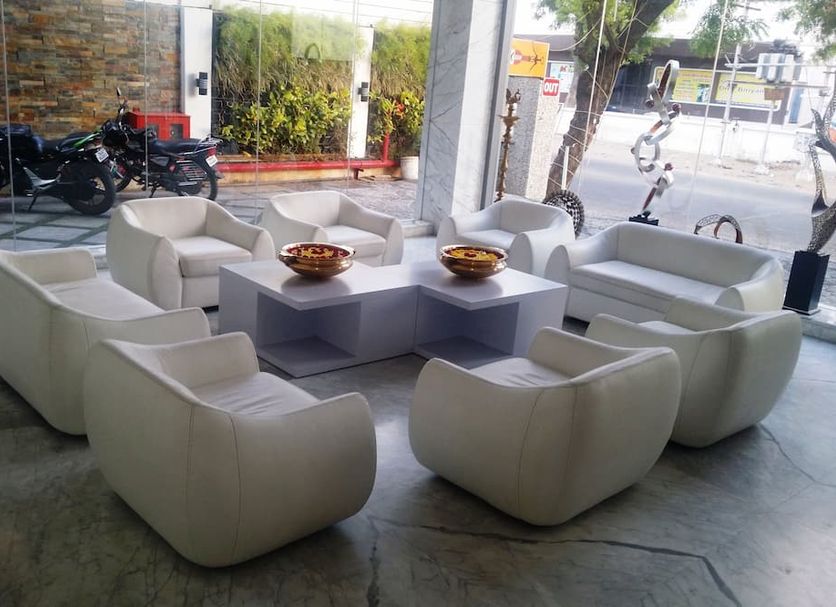 Hotel Le Temps Fort in Tiruchirappalli lobby seating area with white armchairs around low tables