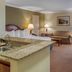 Quality Hotel Conference Center Cincinnati Blue Ash room with kitchenette, two beds, sofa and desk in Cincinnati