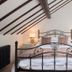 Tudor Farmhouse in Coleford bedroom with wrought-iron bed and sloped ceiling