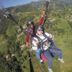 Paragliding over Nagarkot hills, with two people above green terraced valleys