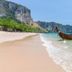 Nadivana Serviced Apartment in Krabi near a tropical beach with longtail boat on clear water