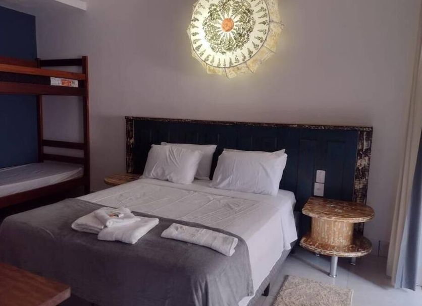 Hospedagem Central in Tiradentes: simple room with double bed, bunk bed, bedside table and wall light