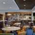 Courtyard by Marriott Boston Norwood/Canton lobby lounge with tables, chairs, and bar area in Norwood
