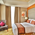 New Century Hotel Pudong Shanghai guest room in Shanghai with king bed, armchair, and large window