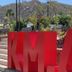 Los Milagros Hotel in Cabo San Lucas with large red letters in a garden and mountain backdrop
