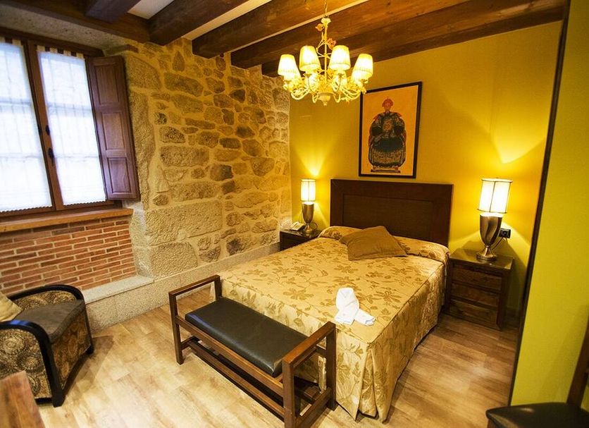 Posada Doña Urraca in Fermoselle, stone-walled guest room with chandelier, double bed and bench