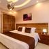 Arabella Residence in Cairo guest room with king bed, mirrored wall, wood accents, and ceiling light fixture