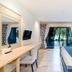 Bhukitta Boutique Hotel Phuket City room with desk, bed, and sliding glass doors to a balcony view